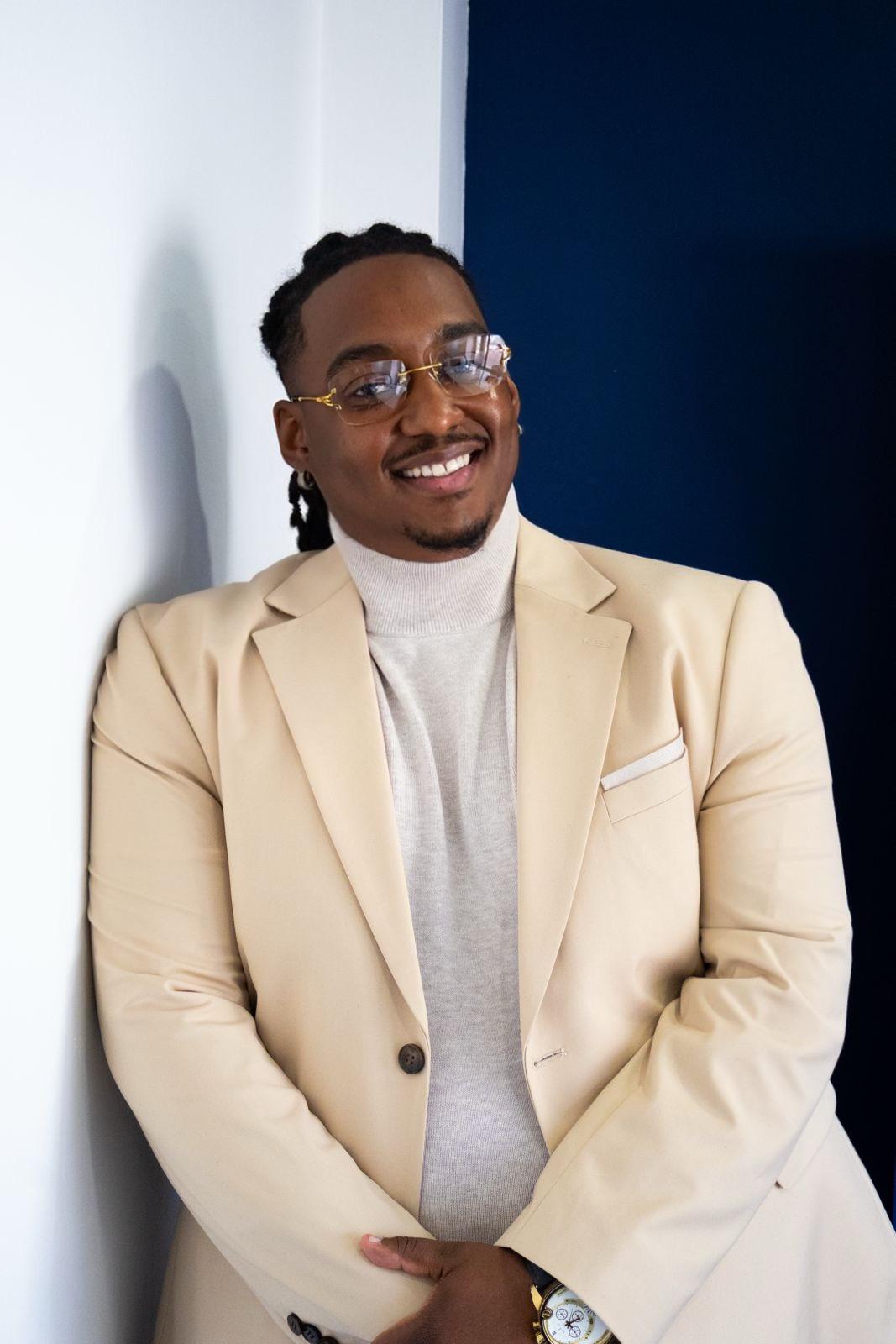 Carlito Henry, sourire franc, habillé en beige clair